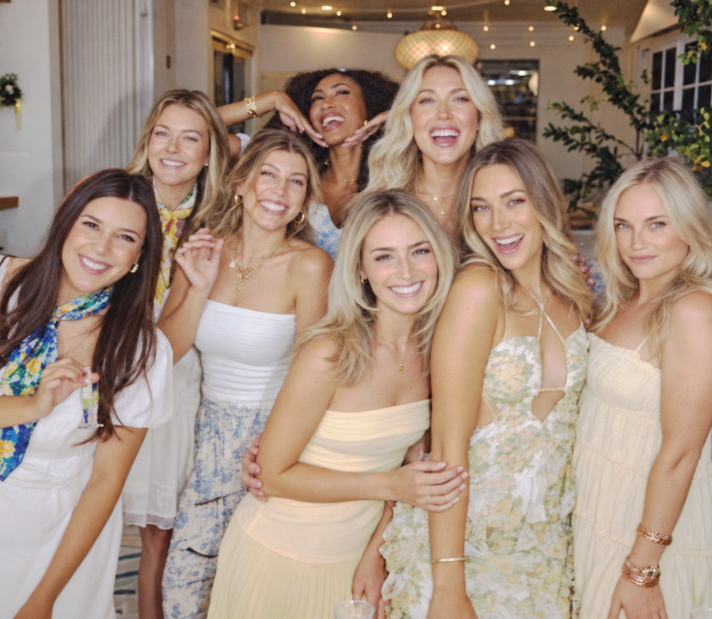 Smiling friends in white, lemon print and soft floral dresses with silk scarves