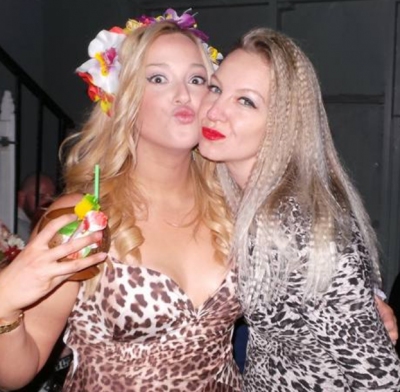The bride and a friend at her Katy Perry themed hens, one in a flower garland, both pulling kissy faces